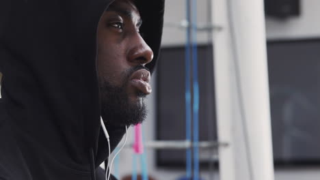 Male-Boxer-Training-In-Gym-Listening-To-Music-On-Headphones-In-Boxing-Ring