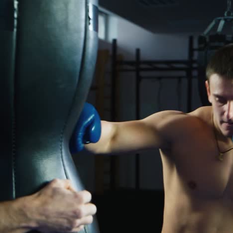 a young boxer practices punches on a punching bag