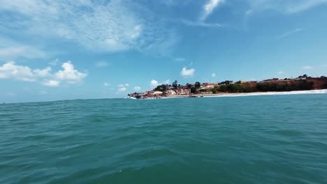 Action-camera-shot-on-top-of-a-small-fishing-boat-sailing-towards-the-Cacimba-beach-in-the-famous-surf-beach-town-of-Baia-Formosa-in-Rio-Grande-do-Norte,-Brazil-on-a-warm-sunny-summer-day