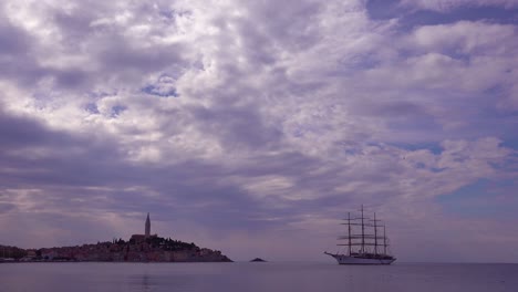 Schöne-Aufnahme-Der-Stadt-Rovinj-In-Kroatien-Mit-Einem-Segelschiff-Mit-Hohem-Mast-In-Der-Ferne