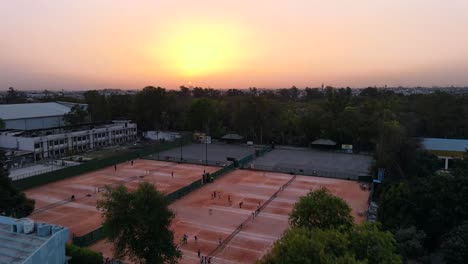 Tomas-De-Drones-De-4k-De-Una-Puesta-De-Sol-En-Una-Ciudad-India-Nueva-Delhi-Por-Encima-De-Los-árboles-Y-Casas-Hermosa-Colonia-Elegante-Club-Punjabi-Bagh-Luz