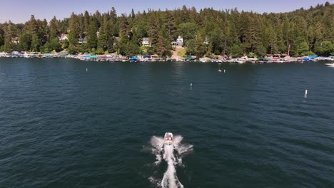 speed-boat-on-lake-arrowhead-california-driving-fast-towards-lakeside-homes-to-dock-AERIAL-DOLLY-FOLLOW