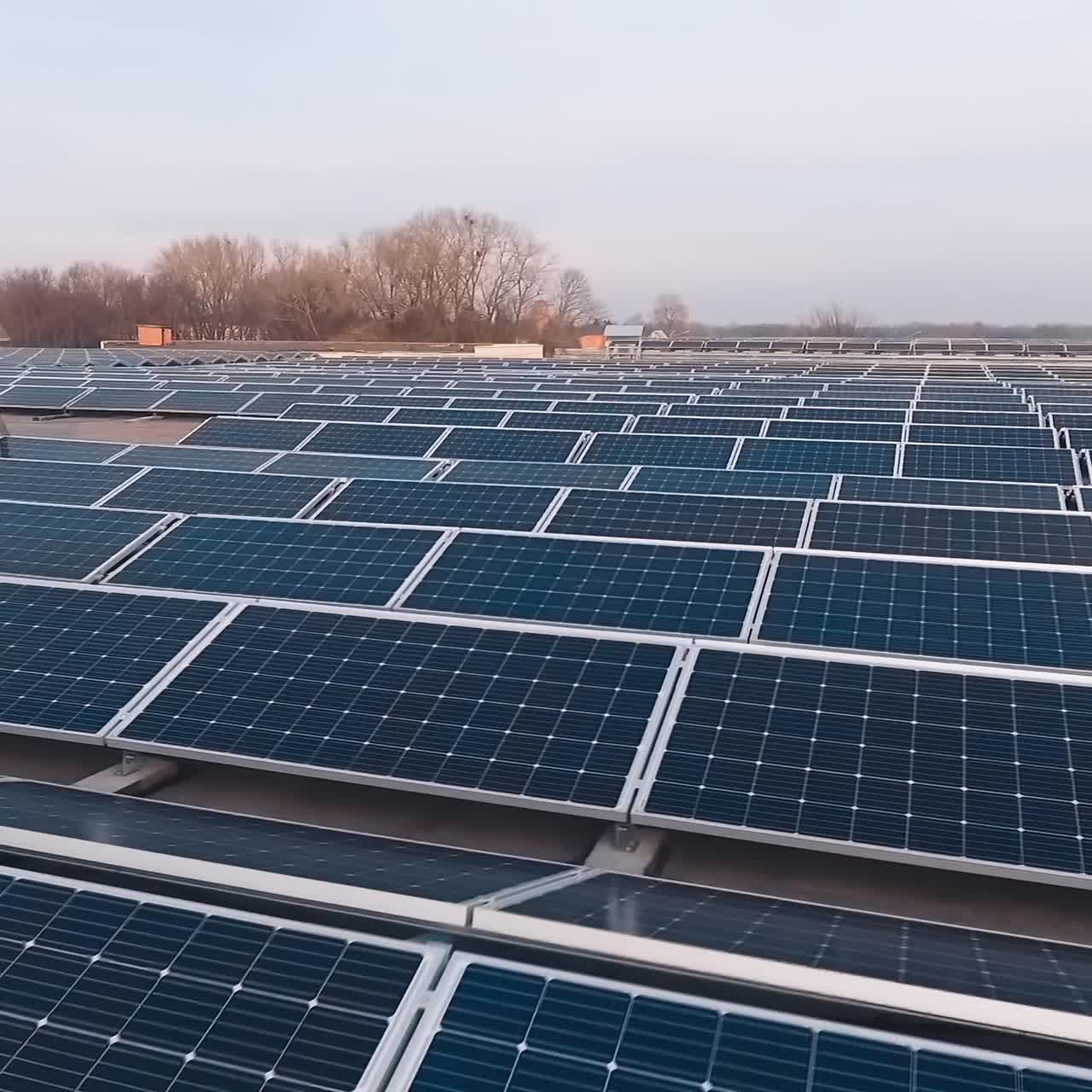 Modern solar power station on roof. Photovoltaic panels generate clean energy from the evening sun. Sustainable ecological energy. Camera moves back.