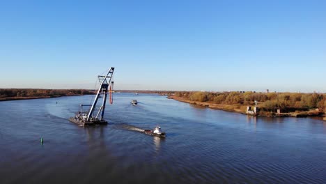 remolcador tirando de la pata flotante con una grúa en el río en barendrecht, países bajos