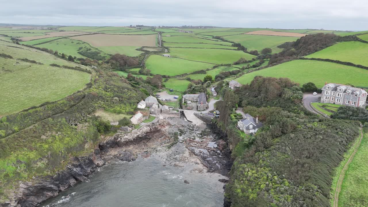 Pull back drone aerial reverse reveal Port Quin Cornwall UK