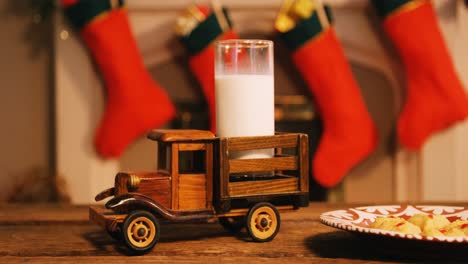 christmas cookies on plate and toy truck with a glass of milk