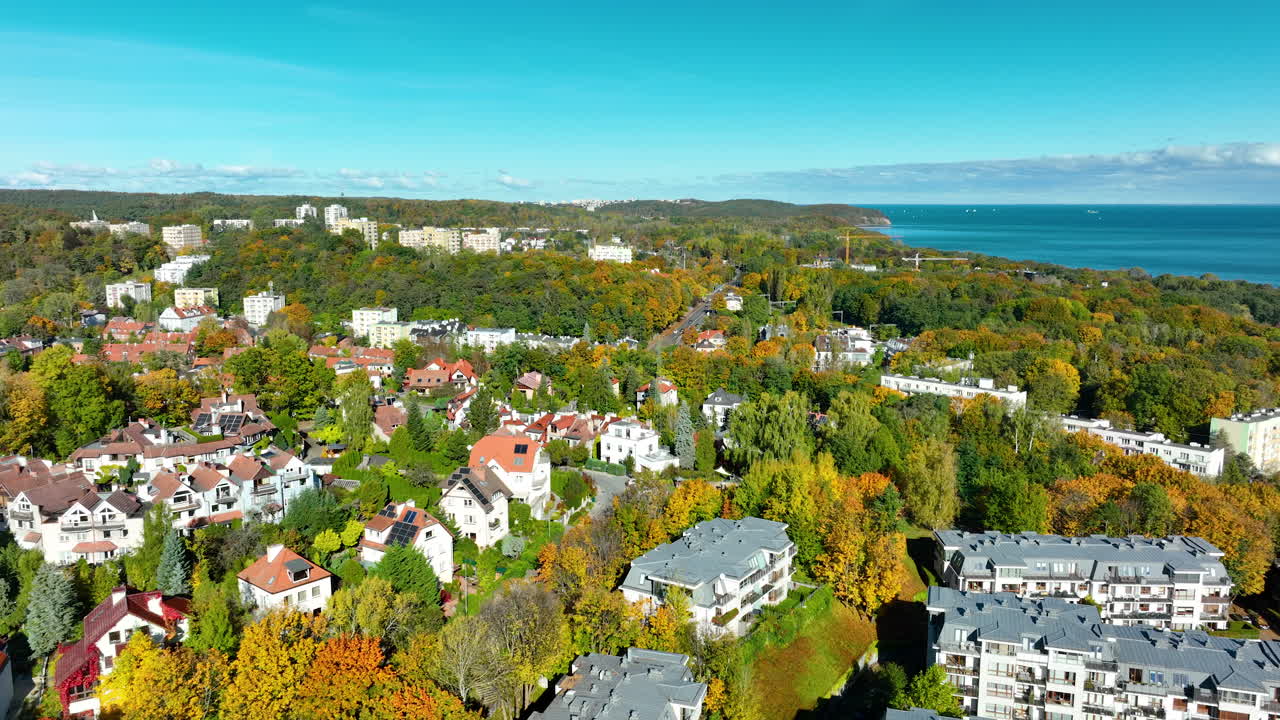 Drone shot of Sopot residential buildings surrounded by colorful autumn trees