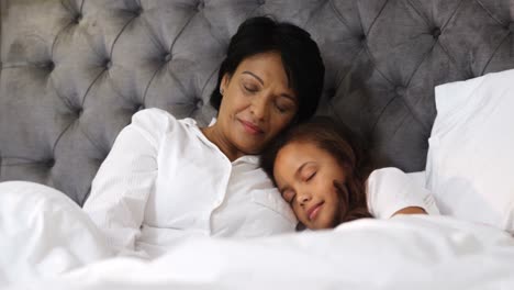 abuela y nieta durmiendo juntas en el dormitorio 4k