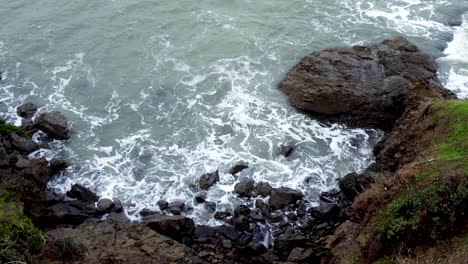 Rugged-coastline-of-waves,-rocks-and-water-on-the-mainland-near-infamous-abandoned-Alcatraz-military-federal-prison-in-San-Francisco,-California-USA