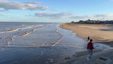 warm coastal sunset scene with two boys playing walking through the image