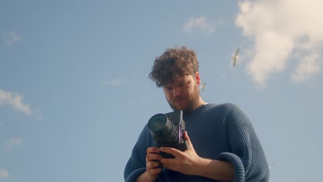 fotógrafo analógico masculino contra el cielo azul en ámsterdam - ángulo bajo