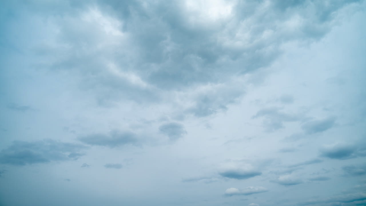 Sky with dark clouds floating across the sky. Timelapse of small white cumulus fluffy clouds