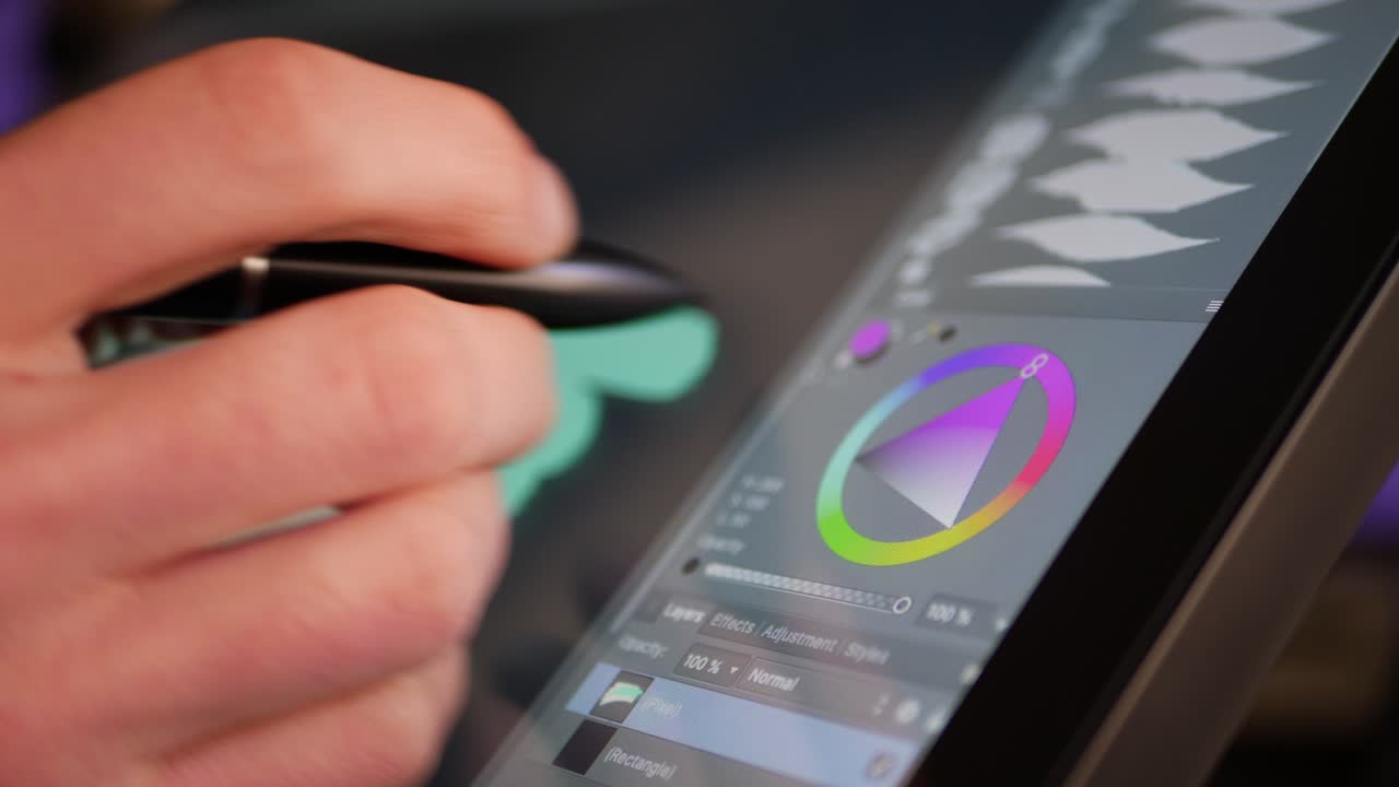 A freelance digital artist or designer picking a color hue and painting with a drawing graphic tablet and pen in an art studio