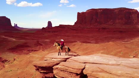 remarkable aerial over a cowboy on horseback overlooking monument valley utah 1