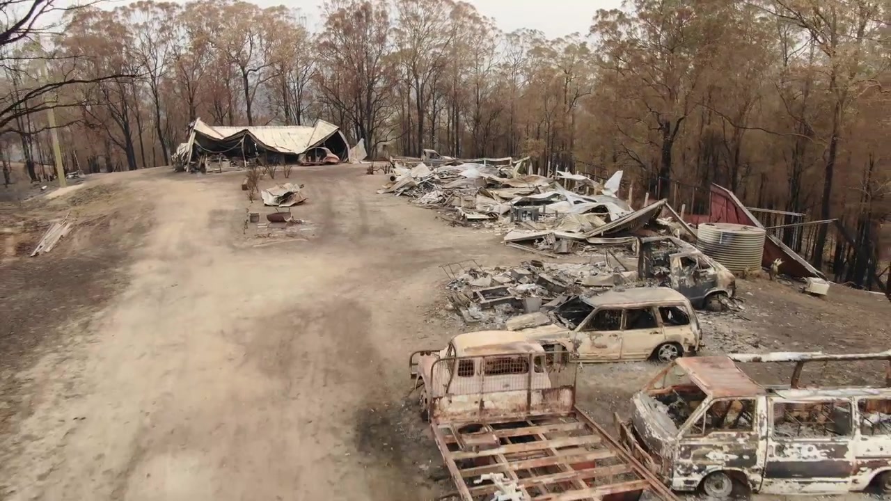山火事後の森林、環境破壊、焼けた車両と田舎の建物、オーストラリア、ニューサウスウェールズ州。空撮、後方へ降下