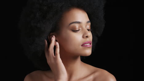Porträt-Einer-Attraktiven-Afroamerikanischen-Frau,-Die-Ihr-Gesicht-Mit-Den-Händen-Berührt,-Einen-Glatten,-Gesunden-Teint-Streichelt-Und-Die-Perfekte-Natürliche-Schönheit-Genießt,-Funky-Afro-Auf-Schwarzem-Hintergrund