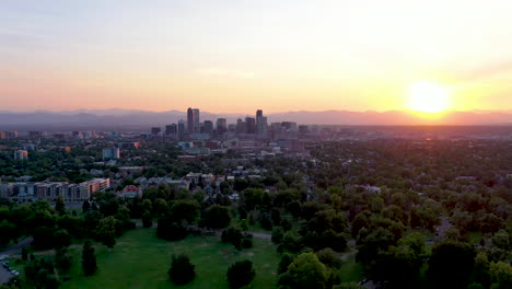 Luftaufnahme-Der-Innenstadt-Von-Denver-In-Der-Ferne,-Umgeben-Von-Einem-Wunderschönen-Sonnenuntergang-Mit-Den-Wohngebieten-Der-Stadt-Im-Vordergrund