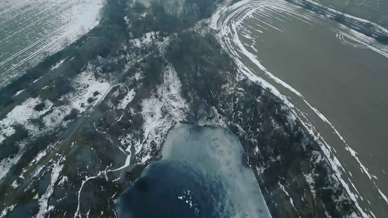 Luchtopname van een bevroren, verlaten, overstroomde leisteengroeve te midden van een desolaat winterlandschap. Ideaal voor een documentaire over industriële mijnbouw, winteromgeving.