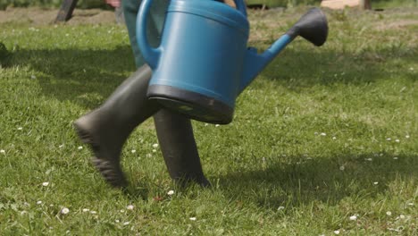 man took the plastic watering can on the lawn