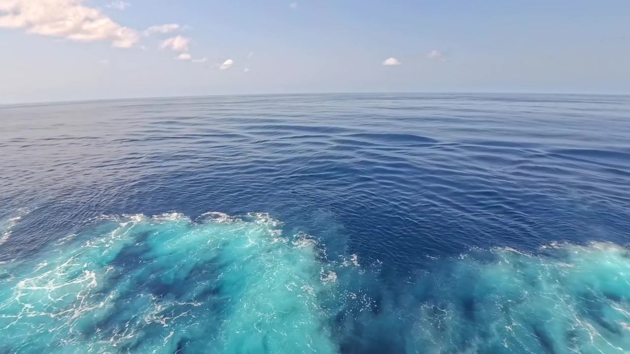 Acqua dell'oceano blu intenso e vivace con scia spumeggiante di un'imbarcazione in movimento