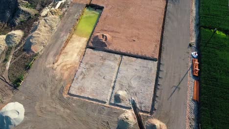 AERIAL---Warehouse-construction-site-foundation,-Austria,-wide-circle-pan