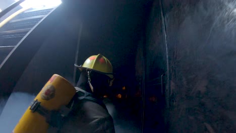 firemen enter a simulator during training and begin to spay water on flames