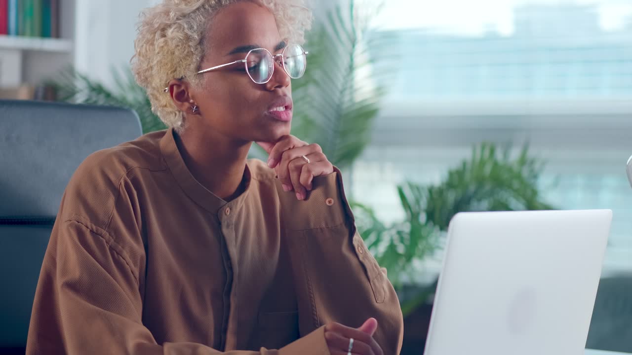 Close up african woman looking at laptop screen thinking on problem solution