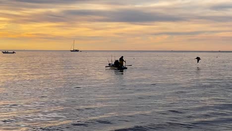 Tiro-De-Un-Grupo-De-Pescadores-Bote-De-Remos-Contra-La-Marea-Saliente-Para-Pescar-En-Bahía-Asunción,-México-Al-Amanecer.