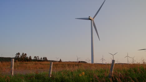 Wind-turbines-farm-producing-green-energy,-wide-shot-panning-right