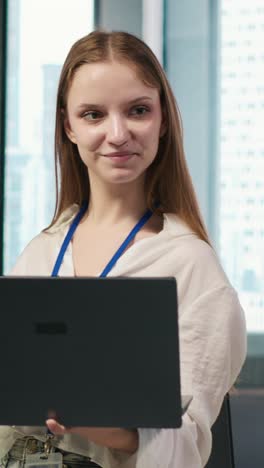 vertical video portrait of young smiling female programmer in office automating with ai