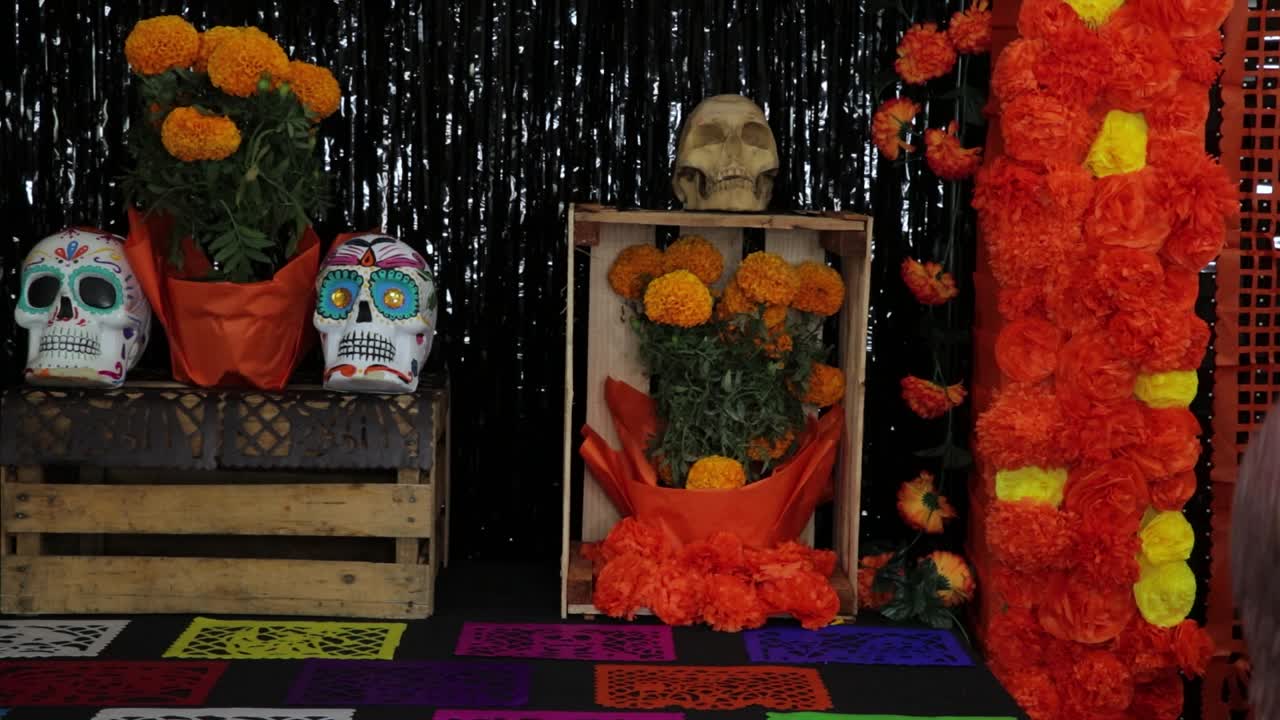 Latino man arranging cempasuchil marigold flowers for Día de Muertos
