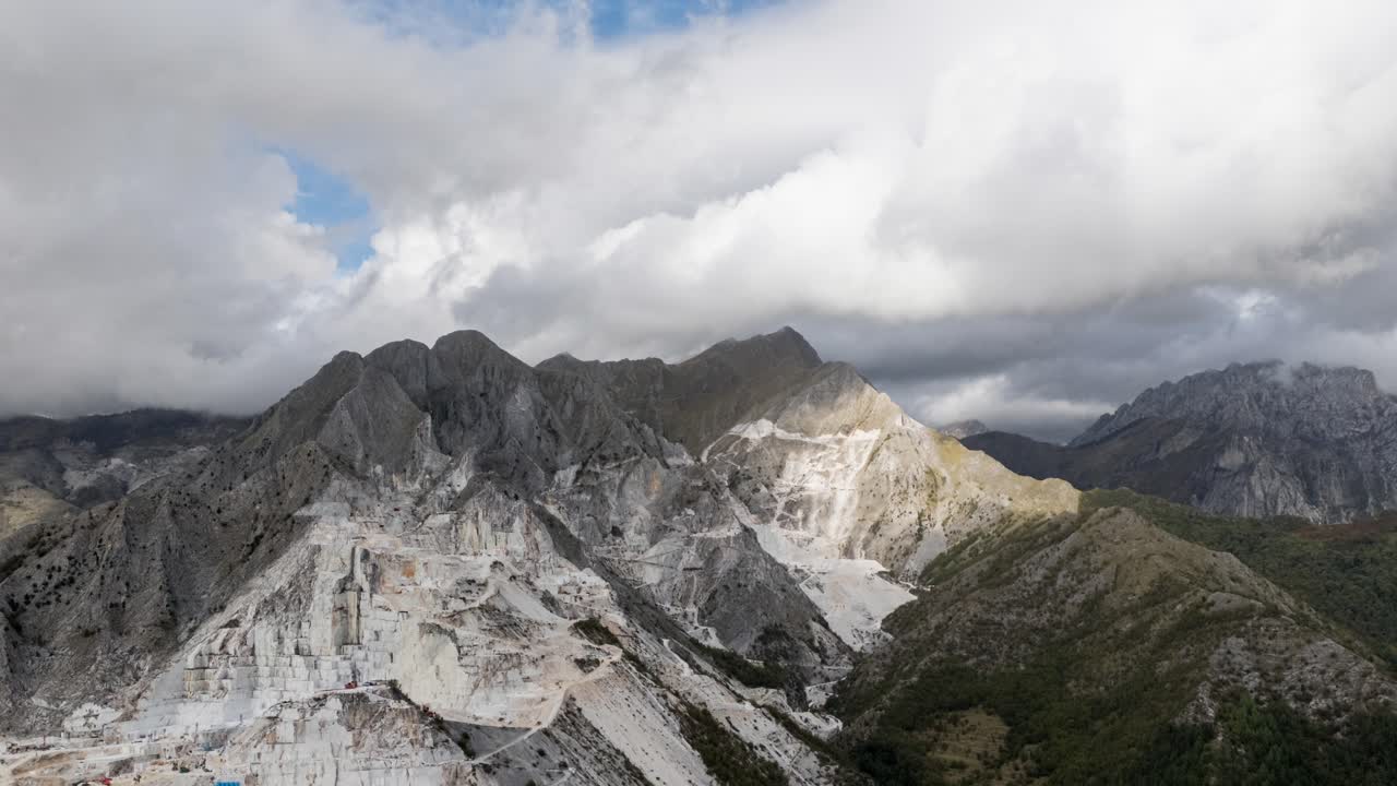 hyperlapse aéreo de las escarpadas canteras de mármol de los alpes apuanos bajo cielos nublados en la toscana