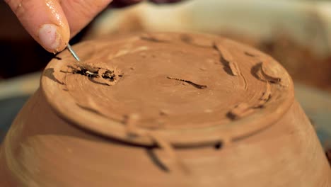 a detailed view on a bottom of a clay bowl during final processing.