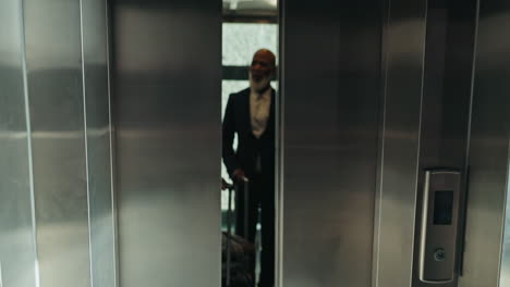 ascensor, equipaje y gente de negocios en el aeropuerto
