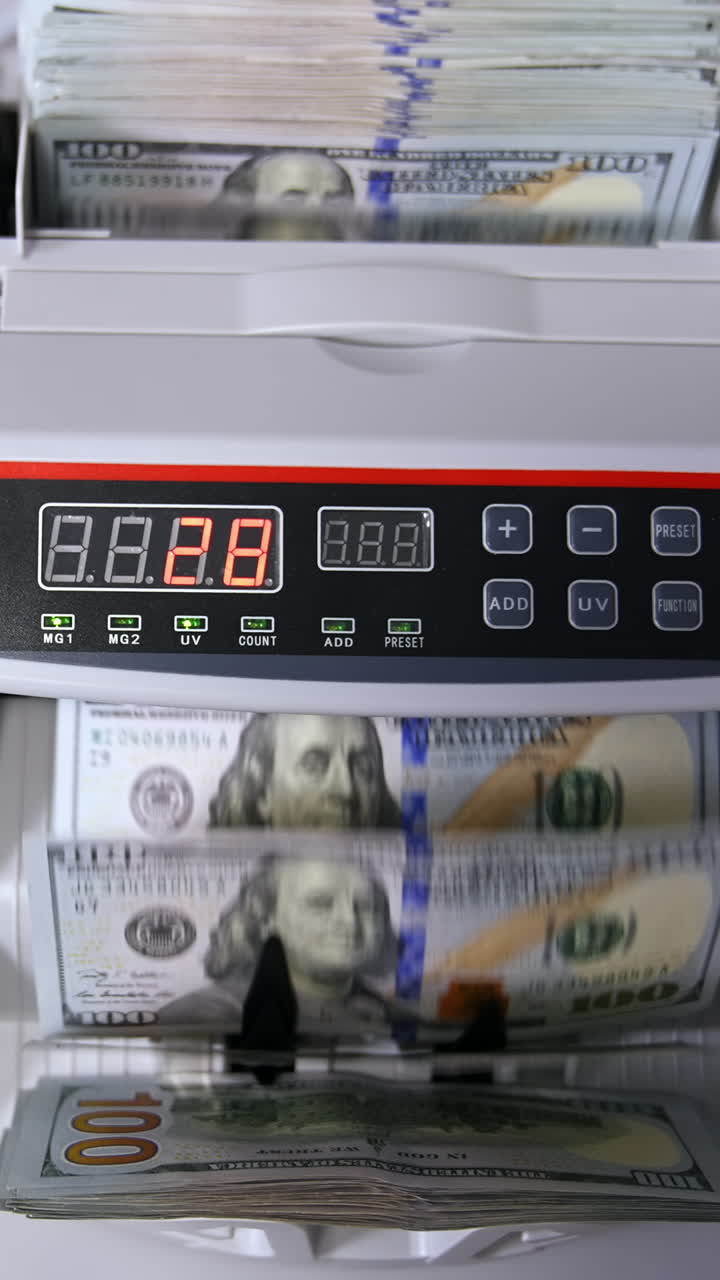 clerk hand counting dollars with electronic money counter machine at bank office or currency exchanger Vertical video