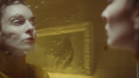 woman looking in wet mirror