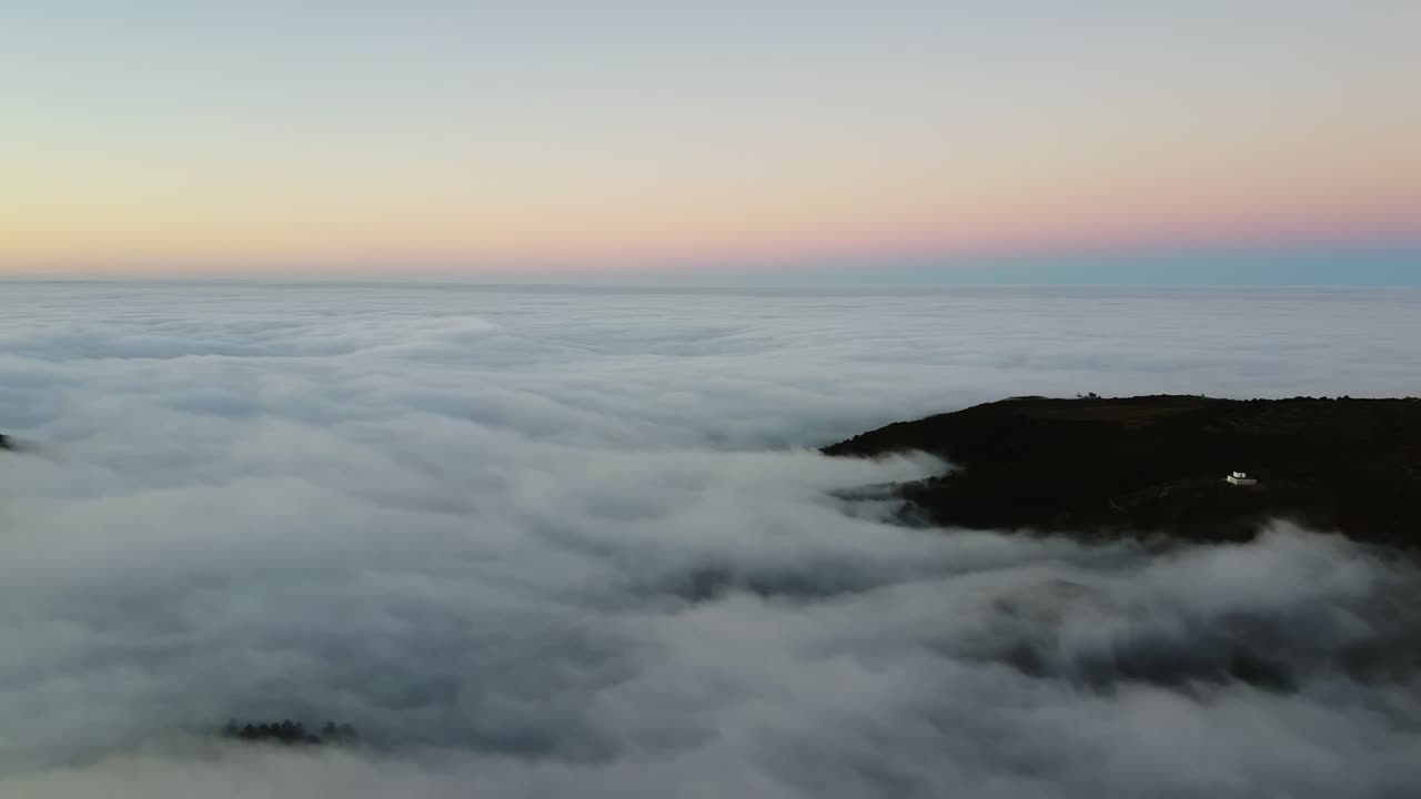imágenes aéreas sobre la espesa niebla o nubes desde las cuales sólo los picos de las montañas del cielo azul son visibles brillantemente iluminados