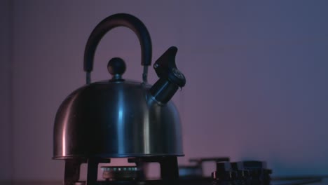 the reflection of light moves on a metal kettle heated on a gas stove in the kitchen