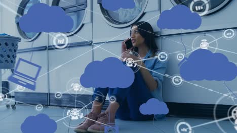 Animation-of-network-of-connections,-clouds-and-percent-going-over-biracial-woman-using-smartphone