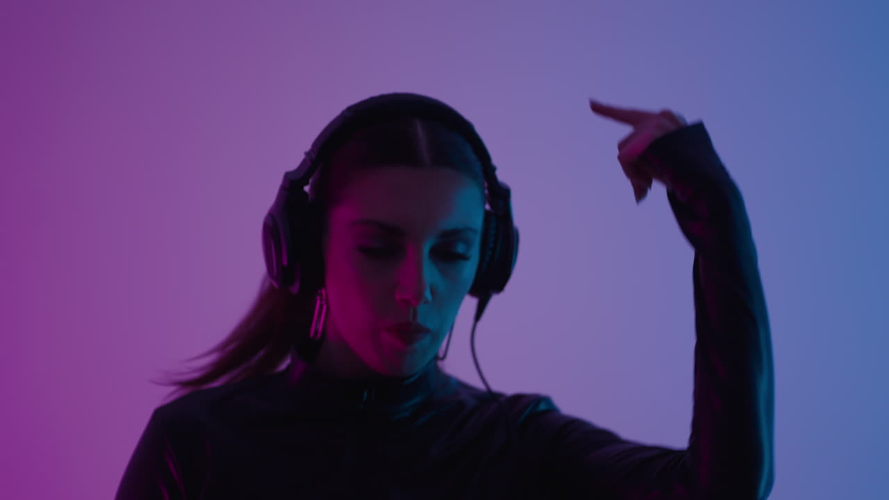 donna che balla con le cuffie sotto le luci al neon