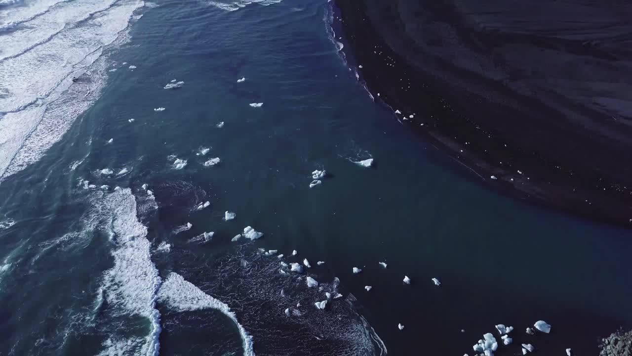 imágenes de drones sobre una playa con algunos pedazos de hielo dentro del agua en un paisaje increíble en islandia