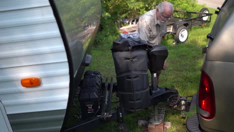 Elderly-man-puts-the-window-up-on-his-pickup-truck-so-the-poodle-won’t-jump-out-and-then-goes-to-hookup-the-RV-to-the-truck