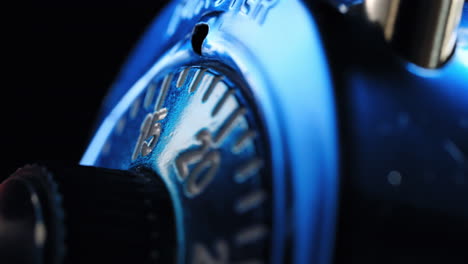 Opening-a-combination-padlock-at-nighttime---close-up-isolated