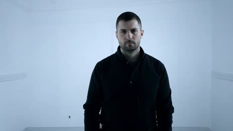 man in black shirt and pants standing in a white room