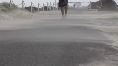 A-person-walking-along-as-a-sandstorm-whips-up-from-a-developing-cyclone