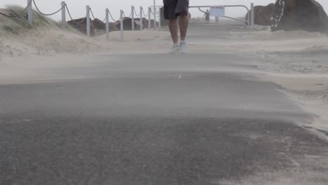 una persona caminando mientras una tormenta de arena surge de un ciclón en desarrollo