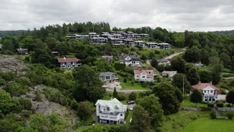 casas escalonadas construidas a lo largo de laderas rocosas y bosques en ljungskile, bohuslan, suecia, aérea