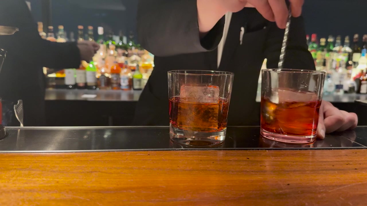 Primo piano di un barista che mescola un cocktail in un bicchiere in un bar a Kanazawa.