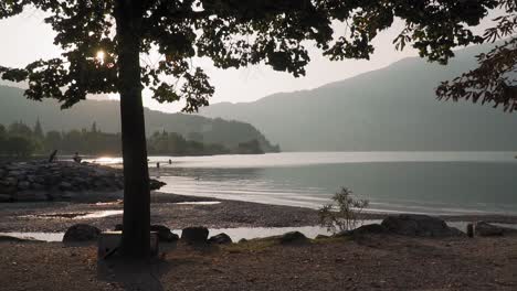 Magischer-Sonnenaufgangsmoment-Am-Gardasee,-Wasser-Glänzt-Mit-Sanftem-Morgenlicht