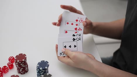hands shuffling and dealing playing cards with poker chips and dice